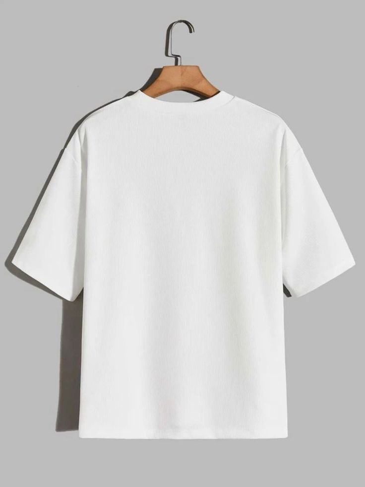 A plain white short-sleeve crewneck t-shirt hanging on a wooden hanger against a solid gray background.