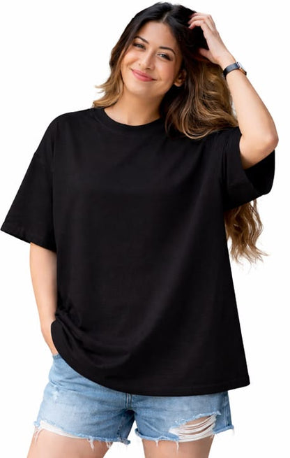 Woman wearing a black oversized t-shirt and denim shorts on a white background